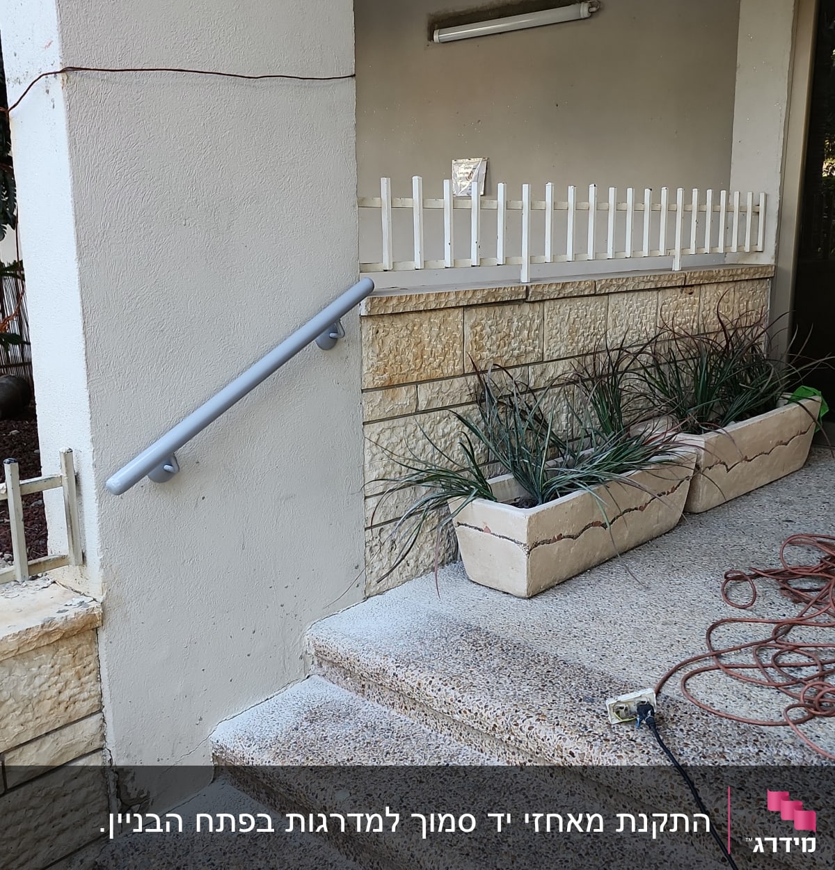 מעקה מתכת אפור ליד מדרגות אבן